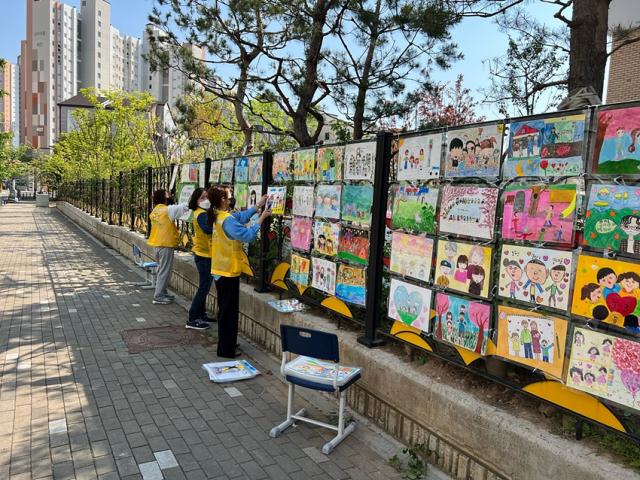 NSP통신-구래초학부모회에서 그림그리기 행사에서 진행한 그림들을 모아 학교 담장에 전시하고 있다. (사진 = 구래초학부모회)