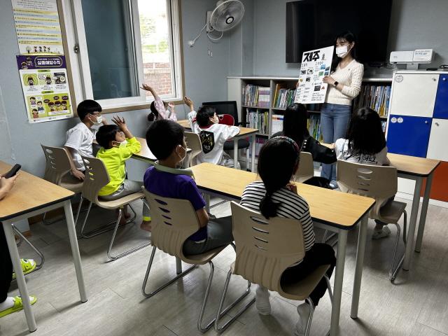 NSP통신-15일 수원 고색동에 있는 밝은별 지역아동센터에서 저학년 초등학생들에게 제주도의 지역문화와 역사를 소개하는 모습. (사진 = 수원시)