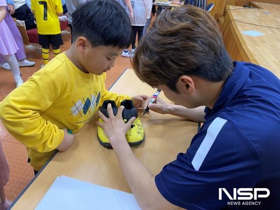 NSP통신-광양백운초등학교 학생에게 축구화에 사인하고 있다 (사진 = 전남드래곤즈)