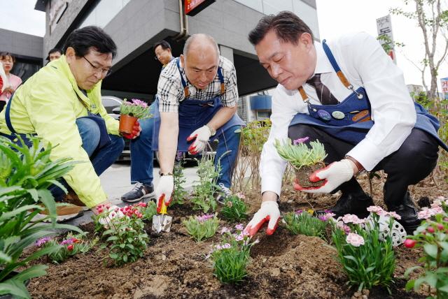 NSP통신-18일 이재준 수원시장(오른쪽)이 국제로타리 3750지구 4지역 회원들과 정원을 조성하고 있다. (사진 = 수원시)