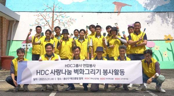 NSP통신-HDC그룹 계열사 임직원들이 벽화 그리기 봉사활동을 진행하고 기념촬영을 하고 있다. (사진 = HDC현대산업개발)