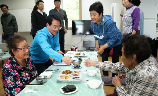 NSP통신-강진원 강진군수가 공동 급식이 이뤄지고 있는 한 마을을 찾아 급식을 돕고 있다. (사진 = 강진군)