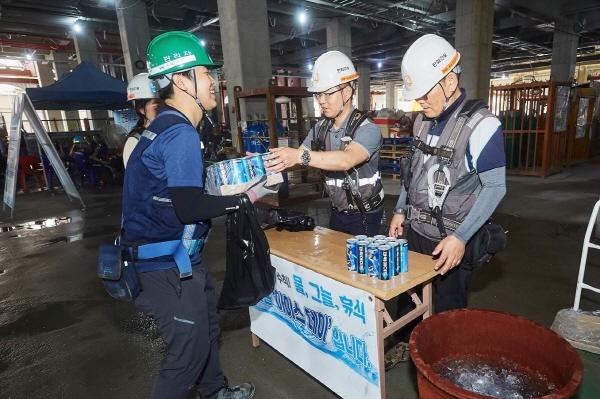 NSP통신-한화 건설부문 관계자들이 한화 건설현장 근로자들에게 음료수를 제공하고 있다. (사진 = 한화 건설부문)