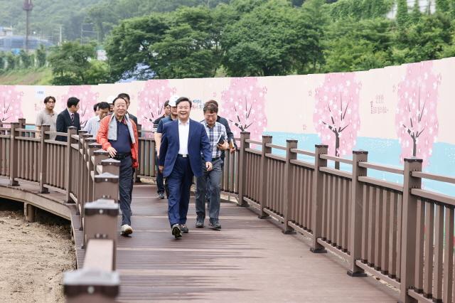 NSP통신-김성제 시장(앞 가운데)이 시민들에게 전 구간을 개방한 백운호수 생태탐방로를 시 관계자들과 걷고 있다. (사진 = 의왕시)
