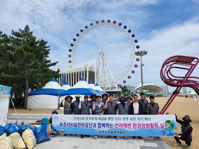 NSP통신-7일 속초시시설관리공단이 속초해수욕장에서 반려해변 환경정화 봉사활동을 실시하고 기념촬영을 하고 있는 모습. (사진 = 속초시)