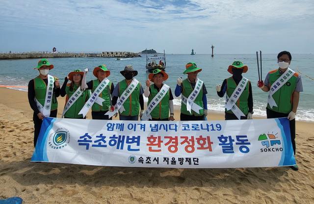 NSP통신-7일 속초시지역자율방재단이 속초해수욕장 환경정화활동을 실시하고 기념촬영 사진을 찍고 있는 모습. (사진 = 속초시)