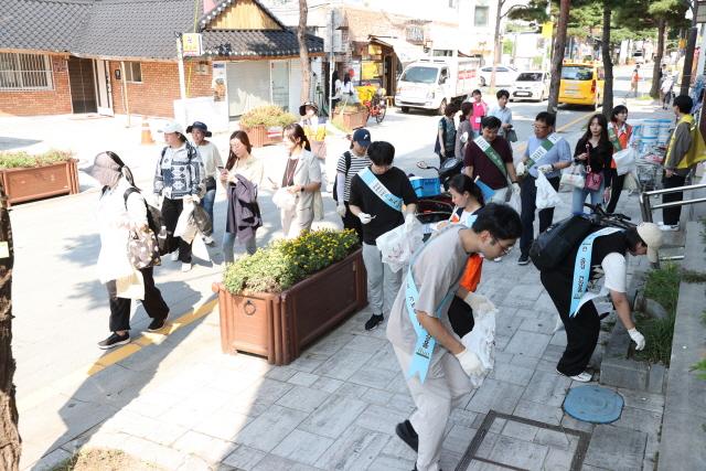 NSP통신-1일 참가자들이 거리를 걸으며 쓰레기를 줍고 있는 모습. (사진 = 수원시)
