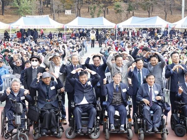 NSP통신-진교훈 서울 강서구청장(두 번째 줄 왼쪽 네 번째)이 제20회 장애인 어울림한마당에서 참석자들과 머리 위로 하트를 그리며 기념촬영을 하고 있다. (사진 = 강서구)