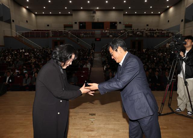 NSP통신-김홍규 강릉시장이 고창영 전 원장에게 강릉명예시민증서를 수여하고 있는 모습. (사진 = 강릉시)