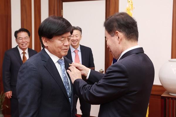 NSP통신-김진표 의장이 김교식 의장비서실장에게 뱃지를 달아주고 있다. (사진 = 국회의장 공보수석실)