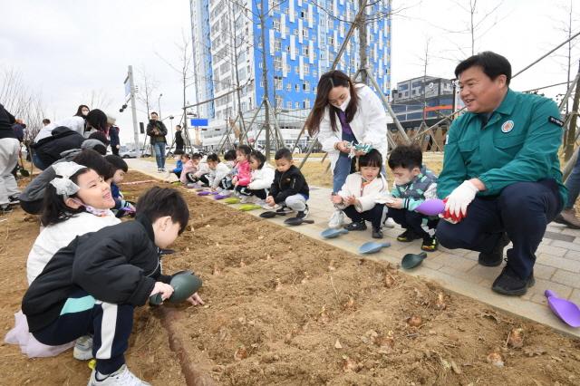 NSP통신-5일 시흥시가 시화MTV 경관녹지에서 시화호 30주년 기념 식목일 나무 심기 행사를 개최했다. 사진은 임병택 시흥시장(오른쪽)이 어린이와 나무를 심는 모습. (사진 = 시흥시)