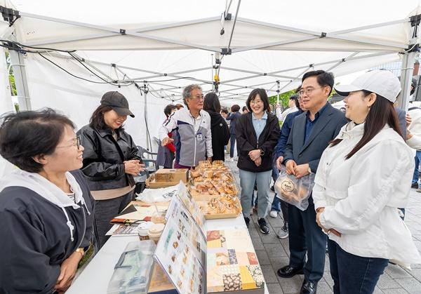 NSP통신-진교훈 서울 강서구청장(오른쪽 두 번째)이 사회적경제기업과 봄맞이 나들이를 주제로 열린 사봄마켓을 찾아 빵과 쿠키를 구매하고 참가자들과 대화를 나누고 있다. (사진 = 강서구)