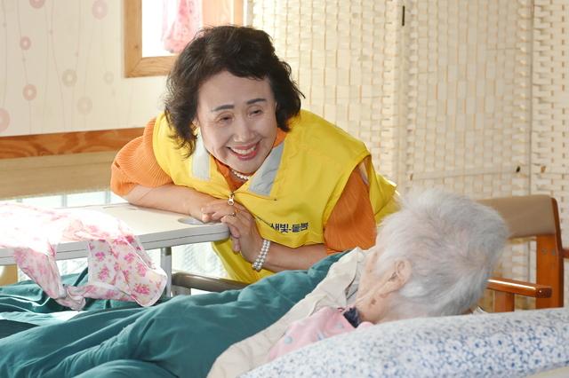 NSP통신-김용자 씨가 요양센터에서 노인과 이야기를 나누고 있다. (사진 = 수원시)