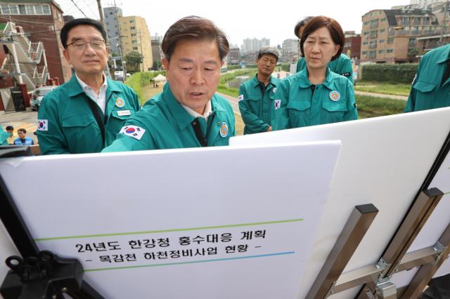 NSP통신-박승원 시장이 목감천 개웅교 현장에서 한화진 환경부 장관과 한강유역환경청장 등 관계기관장에게 목감천 하천정비사업 추진 현황을 설명하고 있다. (사진 = 광명시)