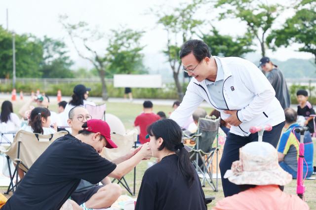 NSP통신-의왕시 왕송호수 잔디광장에서 열린 돗자리 영화관에서 김성제 의왕시장이 시민들과 악수를 나누고 있다. (사진 = 의왕시)