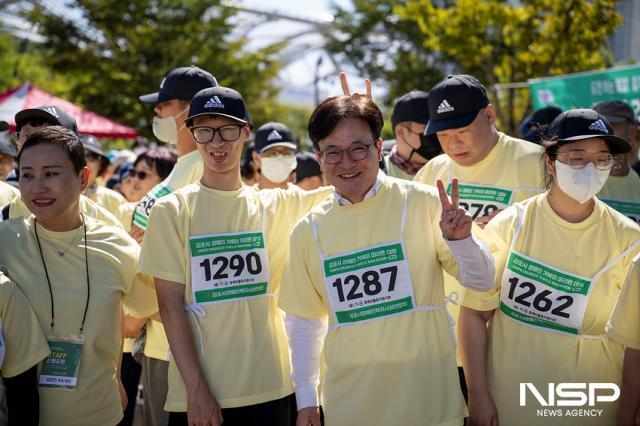 NSP통신-마라톤 대회에 참가한 한 선수가 김병수 김포시장 뒤에서 V이 표시를 하며 장난하는 모습. (사진 = 조이호 기자)