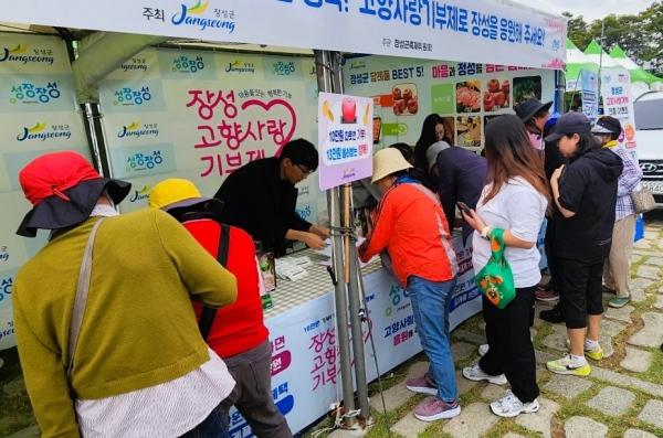 NSP통신-장성군이 황룡강 가을꽃축제장에서 고향사랑기부제 관광객을 대상으로 고향사랑 기금사업 후보사업에 대한 현장 설문을 실시하고 있다. (사진 = 장성군)