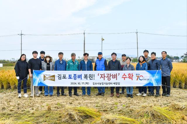 NSP통신-김병수 김포시장이 자광미 수확에 함께한 관게자들과 기념사진 촬영을 하고 있는 모습. (사진 = 김포시)