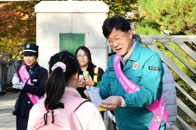 NSP통신-이민근 시장이 5일 별망초등학교 등굣길 캠페인 가운데 일단 멈춤, 아이 먼저 보내주세요라는 어깨띠를 걸고 홍보 물품을 아이들에게 나눠주고 있다. (사진 = 안산시)