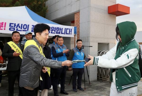 NSP통신-김대중 전남교육감이 14일 한 수험생에게 핫팩을 전하며 격려하고 있다. (사진 = 전남교육청)