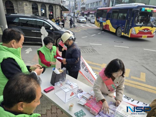NSP통신-2일 오전 예천군 읍내 일원에서 장경숙 예천군 사랑의열매 나눔봉사단장이 관내 주민에게 사랑의 열매 뱃지를 달아주고 예천군청 사회복지과 배열매팀장(사진 오른쪽)이 캠페인 홍보 전단지를 나란히 정돈하고 있는 모습.