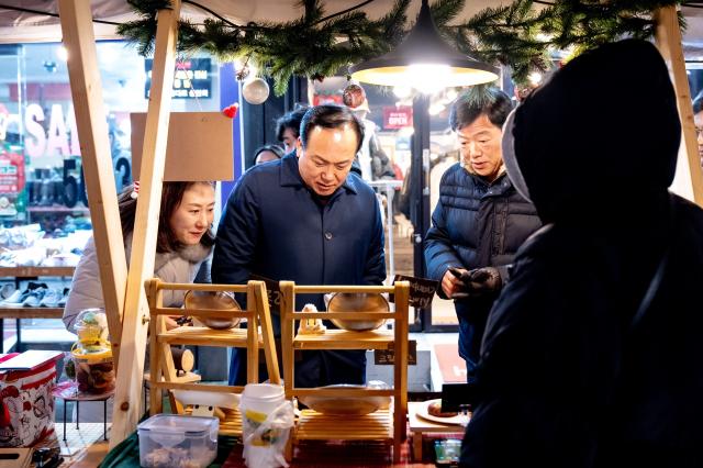 NSP통신-이권재 오산시장(가운데)이 산타마켓 행사에서 상품을 살펴보고 있다. (사진 = 오산시)