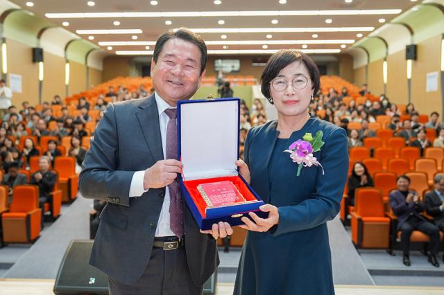 NSP통신-신경호 교육감이 박옥녀 행정국장에게 공로패를 수여하고 기념사진을 찍고 있는 모습. (사진 = 강원도교육청)