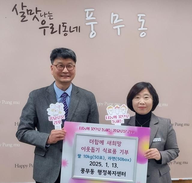 NSP통신-(우측)이혜진 풍무동장이 고성환 본부장으로부터 기탁물품을 전달받고 있는 모습. (사진 = 김포시)
