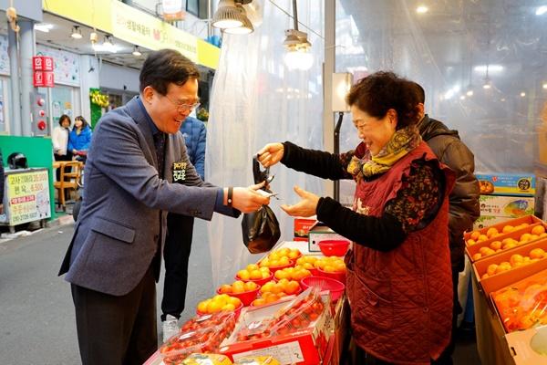 NSP통신-진교훈 강서구청장(왼쪽)이 설 명절을 앞두고 화곡중앙시장을 찾아 과일을 구매하고 있다 (사진 = 강서구)