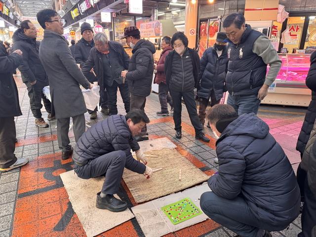 NSP통신-12일 화서시장에서 열린 척사대회에서 시민들이 윷놀이를 하는 모습. (사진 = 수원시)