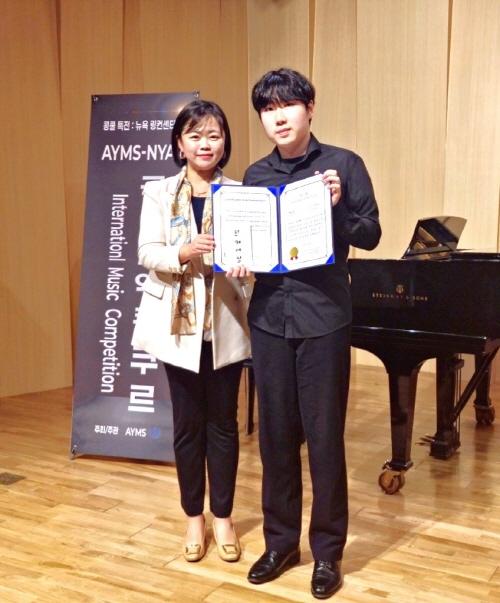 NSP통신-콩쿠르를 주관한 AYMS 대표 안양대 음악학과 사공유정 교수(왼쪽)와 전체 대상 수상자인 한양대학교 피아노 윤승주 학생이 기념사진을 촬영하고 있다. (사진 = 안양대학교)