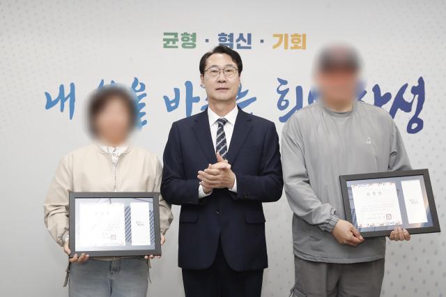 NSP통신-28일 정명근 화성시장(가운데)과 보이스피싱범 검거에 공을 세운 택시 기사 부부가 표창을 받고 기념촬영을 하고 있다. (사진 = 화성시)