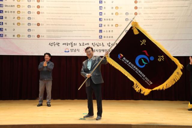 NSP통신-신상진 성남시장이 제15회 경기도장애인체육대회 출전선수단 해단식에 참석해 우승기를 흔들고 있다. (사진 = 성남시)