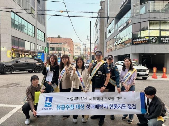 NSP통신-13일 서매매 방지 게시물 부착 여부 점검반이 사진촬영을 하는 모습. (사진 = 수원시)