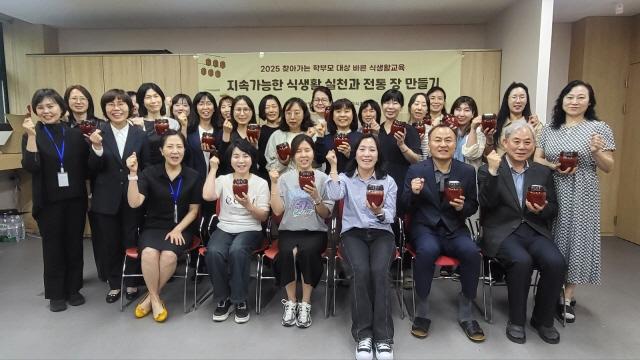 NSP통신-15일 백영고등학교에서 학부모들이 직접만든 전통 장을 들고 기념촬영을 하고 있다. (사진 = 안양시)