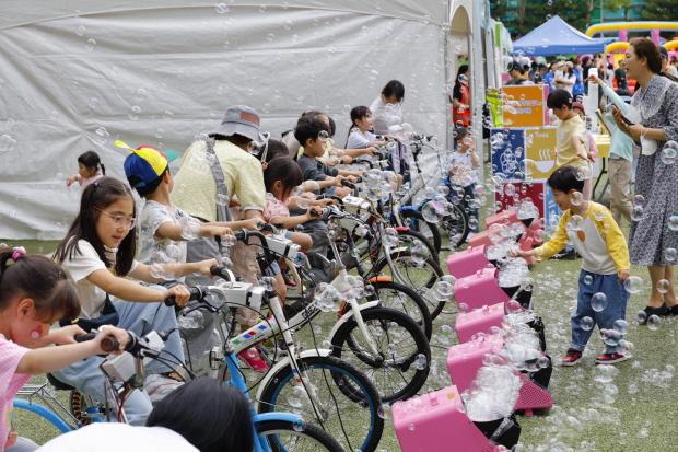NSP통신-17일 우장산 축구장에서 열린 2025 우장산 그린페스타를 찾은 아이들이 자전거 발전기로 비눗방울을 만들고 있다.