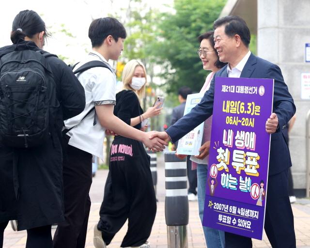 NSP통신-박승원 광명시장이 2일 오전 운산고등학교 앞에서 김정자 운산고등학교장과 함께 등교하는 학생들을 대상으로 투표 독려 캠페인을 진행하는 가운데 한 학생과 악수를 하고 있다. (사진 = 광명시)