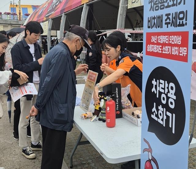 NSP통신-강원소방이 강릉단오제에서 차량용소화기 비치 의무화 캠페인을 펼치고 있는 모습. (사진 = 강원소방)