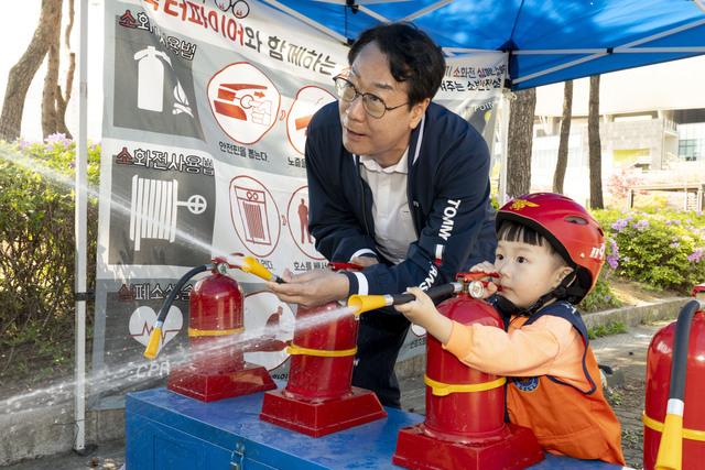 NSP통신-정명근 화성시장이 화성특례시 어린이날 영유아가족 어울림축제에서 어린이와 함께 소화기 사용 체험을 하고 있다. (사진 = 화성시)