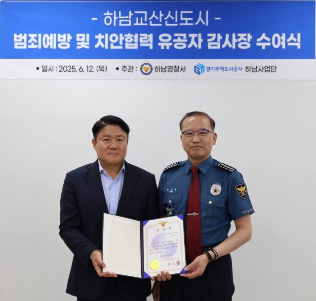 NSP통신-김영진 하남교산개발사업소장(왼쪽)이 박성갑 하남경찰서장으로 부터 감사장을 받고 기념촬영을 하고 있다.
