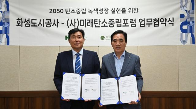 NSP통신-한병홍 화성도시공사 사장(오른쪽)과 이승우 미래탄소중립포럼 상임대표가 업무협약 후 기념촬영을 하는 모습. (사진 = 화성도시공사)