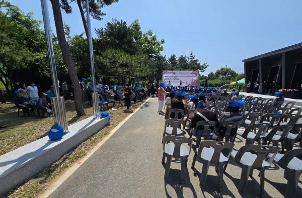 NSP통신-여순사건 홍보관 게관식 참석자들이 준비된 자석에서 이탈해 나무그늘 아래서 행사를 지켜보고 있다. (사진 = 독자제공)