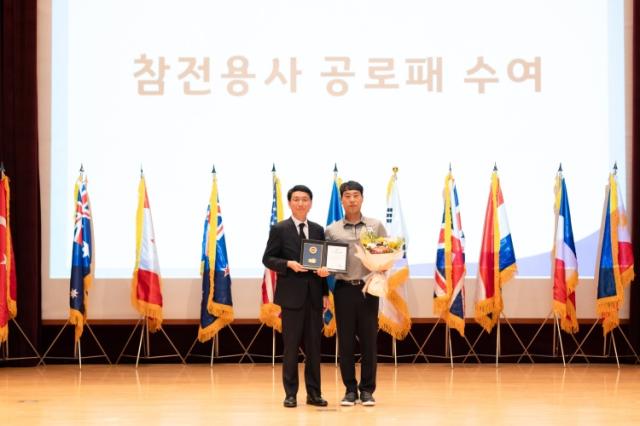 NSP통신-25일 오전 경기도 경제과학진흥원에서 열린 6.25전쟁 제 75주년 행사에서 김성중 행정1부지사가 참전유공자의 자녀에게 참전용사 공로패 수여를 하고 있다. (사진 = 경기도)