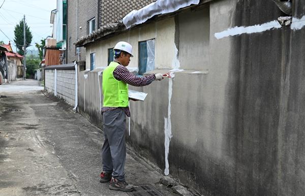 NSP통신-국가유공자 노후주택 보수지원 공사로 작업자가 담장 도장 작업을 하고 있다 (사진 = 요진건설)