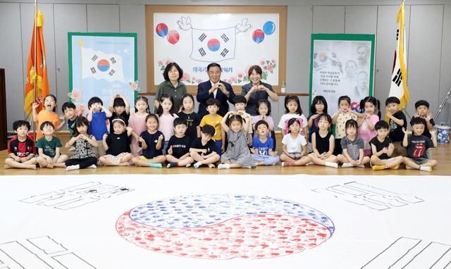 NSP통신-9일 이재식 수원시의회 의장(맨 뒤 가운데)과 원아들이 광복 80주년 기념 태극기 손도장 찍기 행사에서 기념촬영을 하고 있다. (사진 = 수원시의회)
