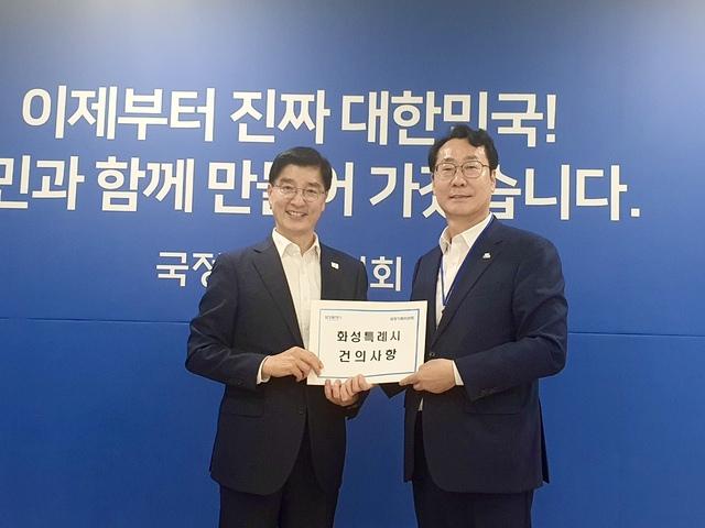 NSP통신-9일 정명근 특례시시장협의회장(오른쪽)이 이해식 국정기획위원회 위원장에게 회성특례시 시정 현안 관련 건의문을 전달하고 기념촬영을 하는 모습. (사진 = 화성시)