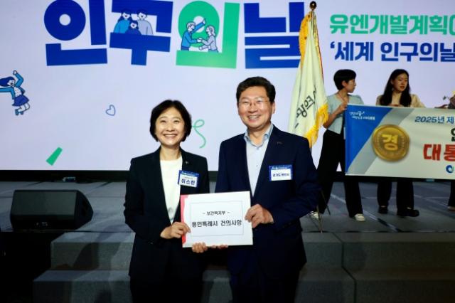 NSP통신-이상일 용인특례시장(오른쪽)이 11일 제14회 인구의 날 기념식에서 이스란 보건복지부 제1차관(왼쪽)에게 사회복지 서비스 향상과 종사자의 처우개선 내용을 담은 건의문을 전달했다. (사진 = 용인특례시)