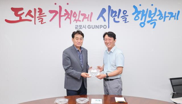 NSP통신-하은호 군포시장(왼쪽)이 환경공무직 근로자들에게 넥쿨러를 전달했다. 사진은 기념촬영 모습. (사진 = 군포시)
