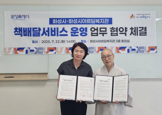 NSP통신-22일 윤미영 화성시 도서관정책과장(왼쪽)과 화성시아르딤복지관장 도선스님이 책배달서비스 운영을 위한 업무협약 후 기념촬영을 하는 모습. (사진 = 화성시)