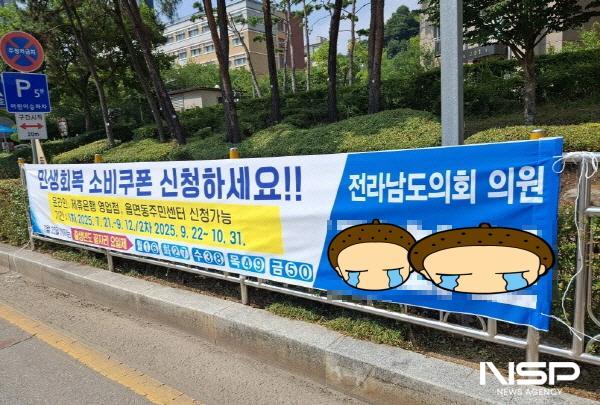 NSP통신-여수시 소라면 일대에 정부의 민생회복 소비쿠폰 안내를 명분으로 게시된 전남도의원 이름이 들어간 불법 현수막 (사진 = 서순곤 기자)